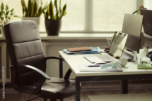 Konstfotografi Office workstation standing ready with laptop, monitor, documents, signaling organized business workflow and employee absence