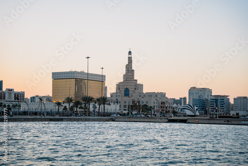 Valokuva Distant view of a city skyline with buildings and a spiral minaret mosque