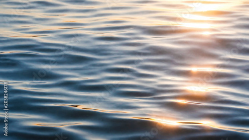 Serene Water Surface with Gentle Waves and Sunlight Reflections