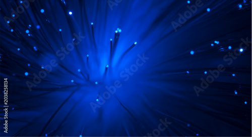 Tableau sur toile Glowing blue fiber optic cables radiate light beams in a dark background conveyi