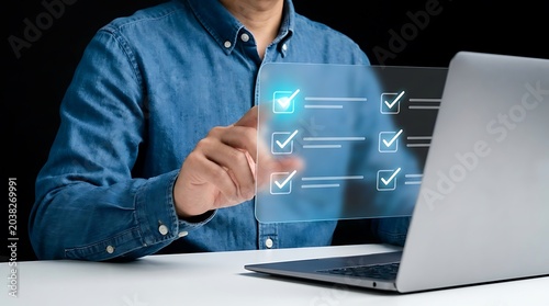 Professional in Blue Shirt Gesturing Toward Floating Digital Checklist Icons on Laptop