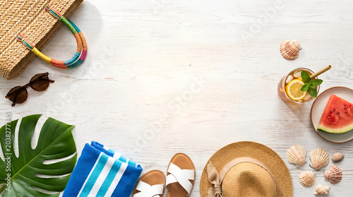 Summer Beach Flat Lay with Straw Hat Bag Sandals Sunglasses Watermelon and Monstera Leaf on White Wood Background with Copy Space