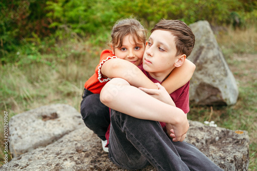 Cuadro en lienzo Child girl hugging teenager brother during peaceful countryside moment