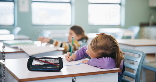 Photos Education, student and writing with girl child at desk in classroom for assignment or development