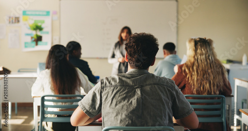 Fotografie Classroom, education and listening with back of students at college for development or learning