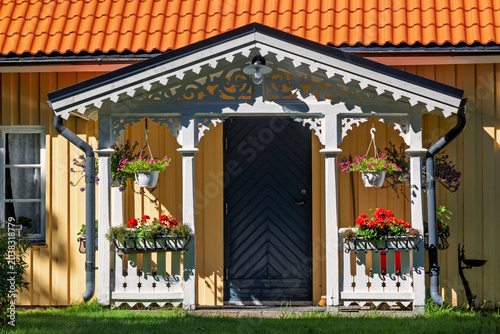 Tableau sur toile Entrance with a porch and beautiful joinery on a cottage with summer flowers