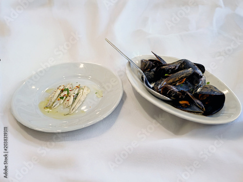 Antipasto di pesce con alici marinate e impepata di cozze su tavola elegante 0321