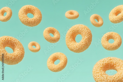 A collection of golden, crunchy cereal rings suspended against a bright teal backdrop. The rings are scattered and appear to be floating, creating a playful and appetizing visual