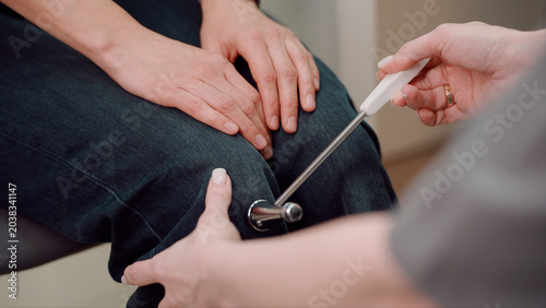 Photos A neurologist knocks on the knee with a hammer to check the reaction