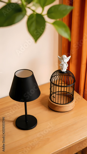 Black lamp and golden birdcage on wooden desk