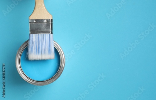 Foto Can of paint and brush on blue background, top view, space for text