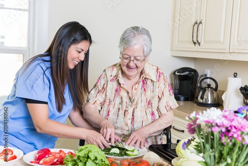 Caregiver assisting senior woman with healthy meal preparation