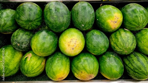 Tableau sur toile Fresh green watermelons are stacked in a crate for sale at the market