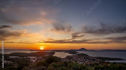 Scenic sunset over coastal town and islands with dramatic clouds