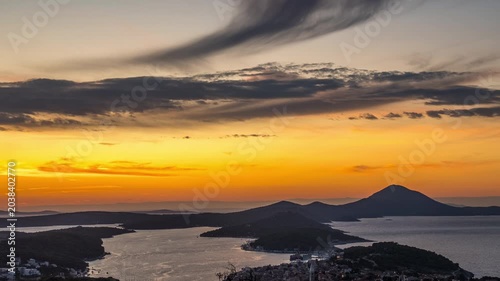 Dramatic sunset over Croatian islands with vibrant orange sky and dark mountains
