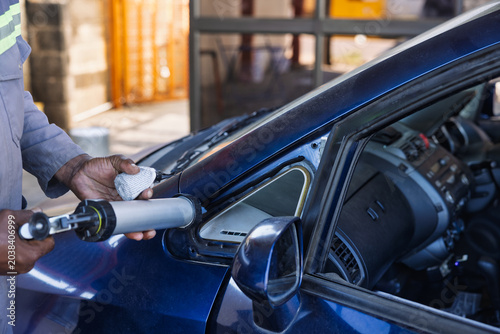Photos African Worker Repairing Car Window Frame with Sealant Gun replacement glass rep
