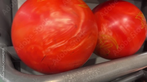 Red bowling ball in ball return rack, close up bowling alley detail