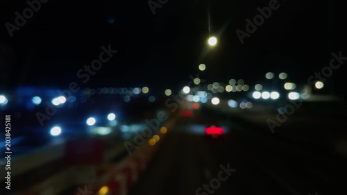 Defocused night view of Hong Kong highway traffic and distant architecture.