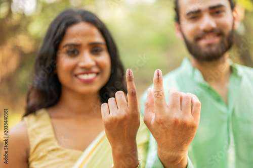 Indian man and woman showing elections mark on the finger