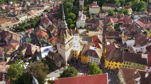 Aerial view of Sighisoara clock tower and medieval citadel in Transylvania during summer afternoon.
