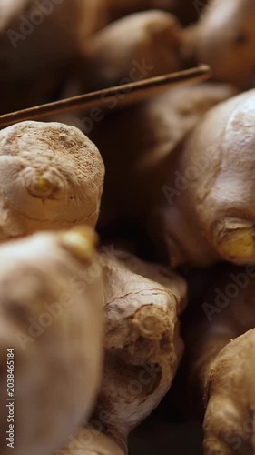 Vertical: Rough and richly textured ginger roots piled at an Italian market stall, a powerful natural remedy and bold culinary ingredient growing in popularity across contemporary Italian kitchens.