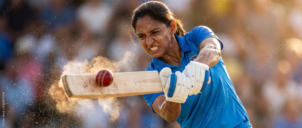 Naklejka premium Female cricket batter hitting ball with dust burst in action close up. Concept of women cricket, dynamic sports advertising, match intensity, athlete power and tournament promo.