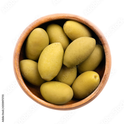 Cerignola olives with pits, in a wooden bowl. Known as Bella di Cerignola, whole, large premium Italian table olives, picked when they are still unripe, and then preserved in salt vinegar brine. Photo