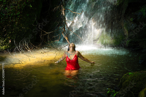 Tableau sur toile Yogapose einer Tattoofrau bei einem Naturwasserfall