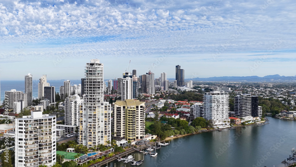 Obraz premium Aerial View of Gold Coast Skyline and Waterways Under Cloudy Sky