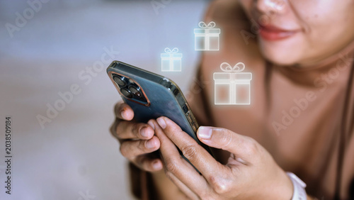 Woman Using Smartphone with Floating Digital Gift Box Icons — Mobile Rewards and Loyalty Program Concept