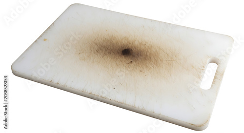 Isolated studio shot of a grimy, well-worn plastic kitchen cutting board, showing its long history