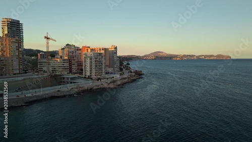 Calpe coastal skyline with seaside apartment towers and calm Mediterranean bay at sunrise Spain
