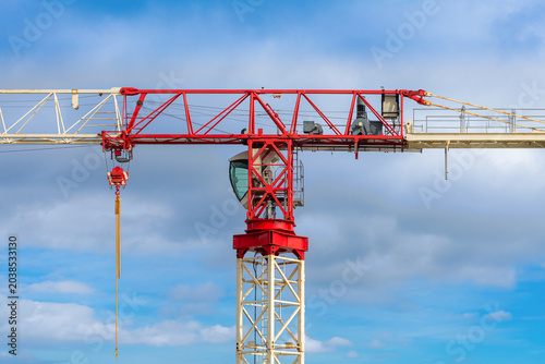 Red and White Tower Crane Against Dramatic Cloudy Sky