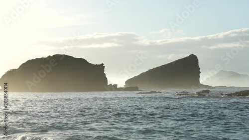 A giant sea stack rock on the coast of Papuma beach with beautiful ocean waves, a popular travel destination in East Java, Indonesia
