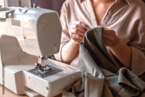 Fotografija Upcycling clothing, woman repairing and altering garment at home, second life fa