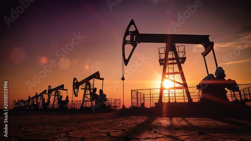 Oil pumps silhouetted at sunset energy industry and extraction