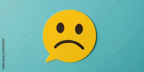Depiction of a displeased customer using a paper cut emoticon for illustrating negative feedback