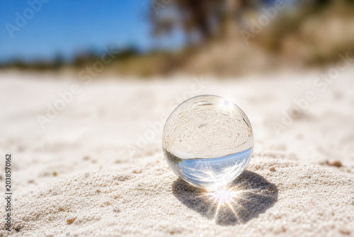 Glass Ball Reflecting Sky on Sand Beach Bright Midday Sun
