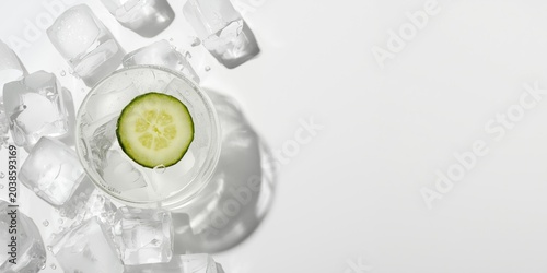 Fresh cucumber slice beverage on ice arranged on white background with copy space