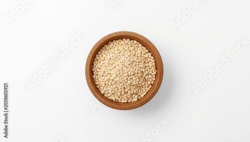 Flat overhead image of unprocessed grains in a round wooden bowl with a simple white background