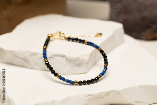 Handmade beaded bracelet featuring lapis lazuli beads, black spinel beads, and gold spacer beads. Fashion jewelry accessory for jewelry making.