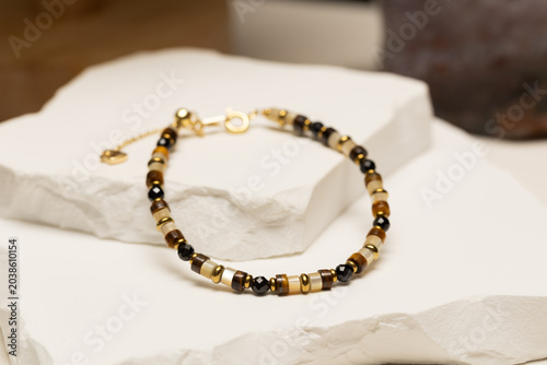 Handmade beaded bracelet featuring tiger eye beads, pearl beads, black spinel beads, and gold spacer beads. Fashion jewelry accessory for jewelry making and DIY crafts.
