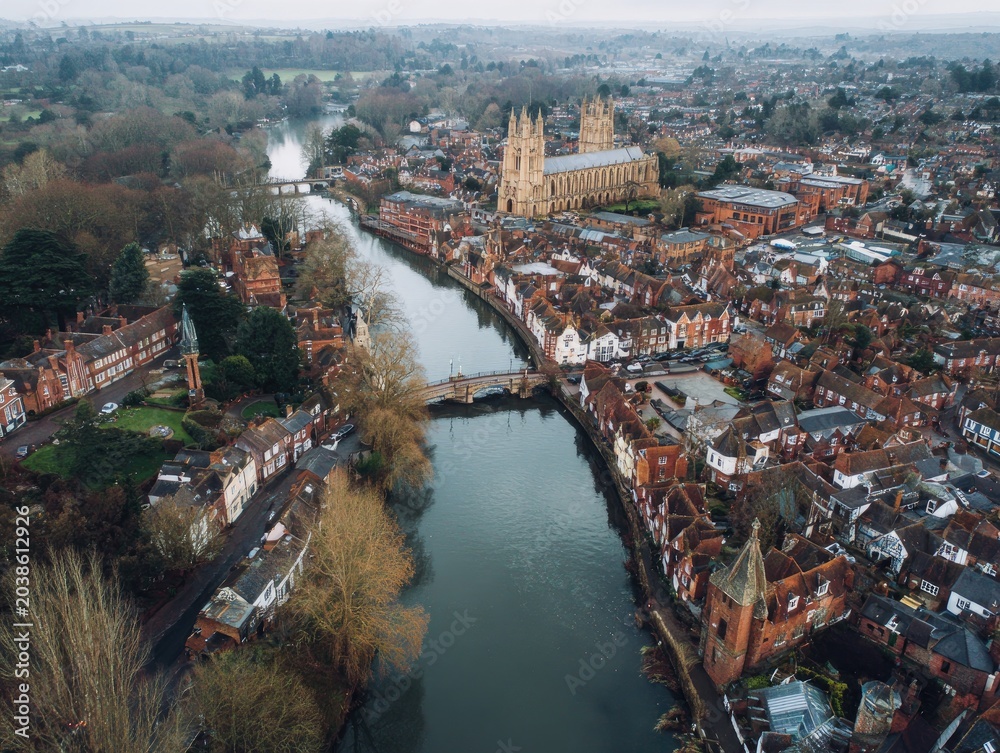 Obraz premium Aerial view of a historic European town with a river, cathedral, and surrounding landscape