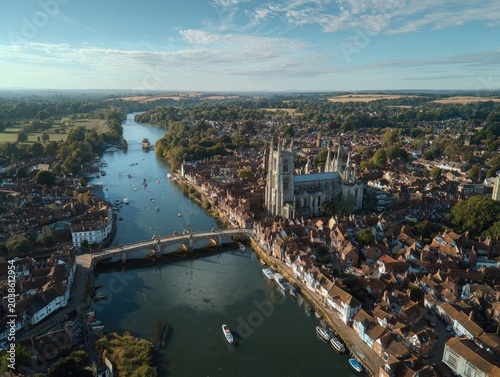 Aerial view of a historic town with a river, bridge, and cathedral
