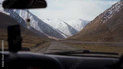 Road Trip Through Mountain Valley with Snow Capped Peaks View from Car Inside