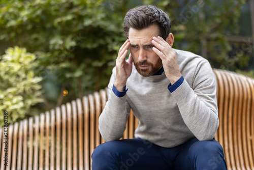 Man suffering from headache and stress in the park