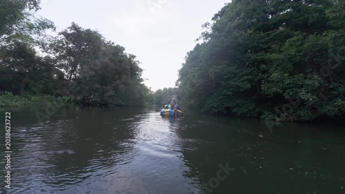 River Rafting on Calm Tropical River Surrounded by Lush Green Forest