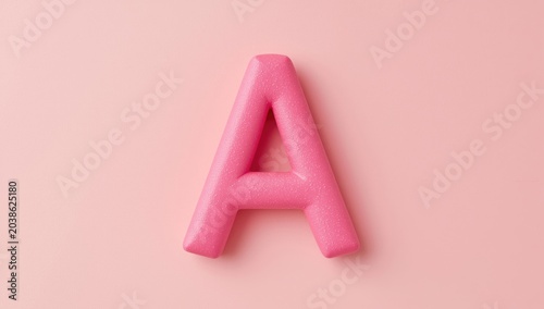Fun and creative pink foam letter A displayed on a soft pastel color background