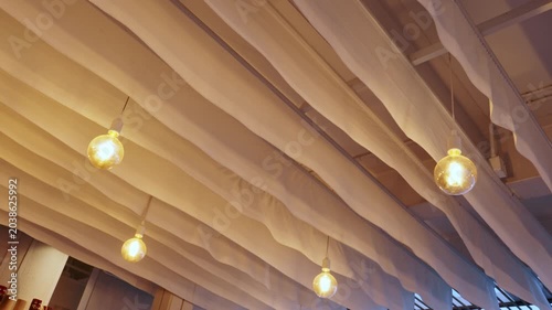 Pendant Globe Bulbs Hanging Under Pergola With Draped Fabric Canopy at Dusk Outdoor Ambiance