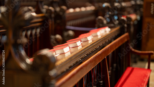 Cuadro en lienzo Row of red hymn book placed neatly on dark wooden church pew in chapel interior